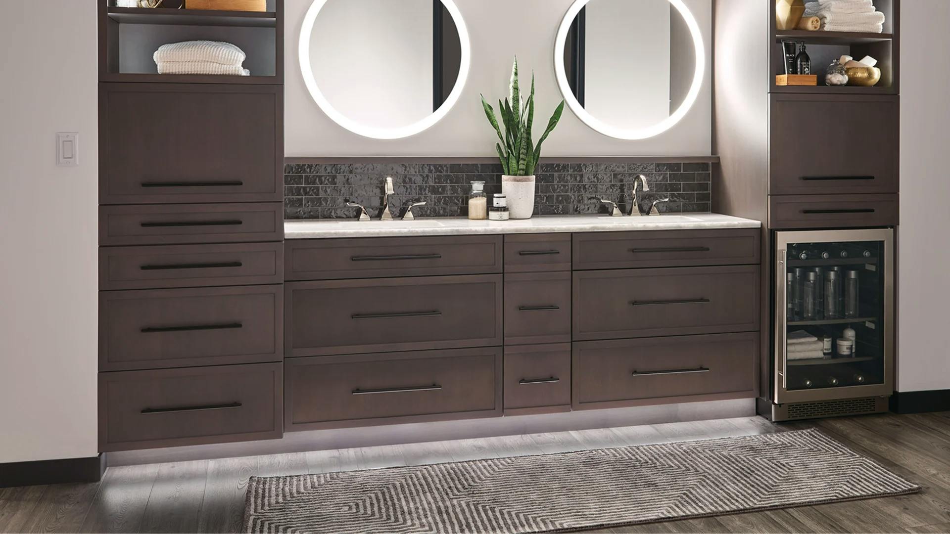 Bathroom with two round mirrors and two sinks displaying toe kick lights under the counter.