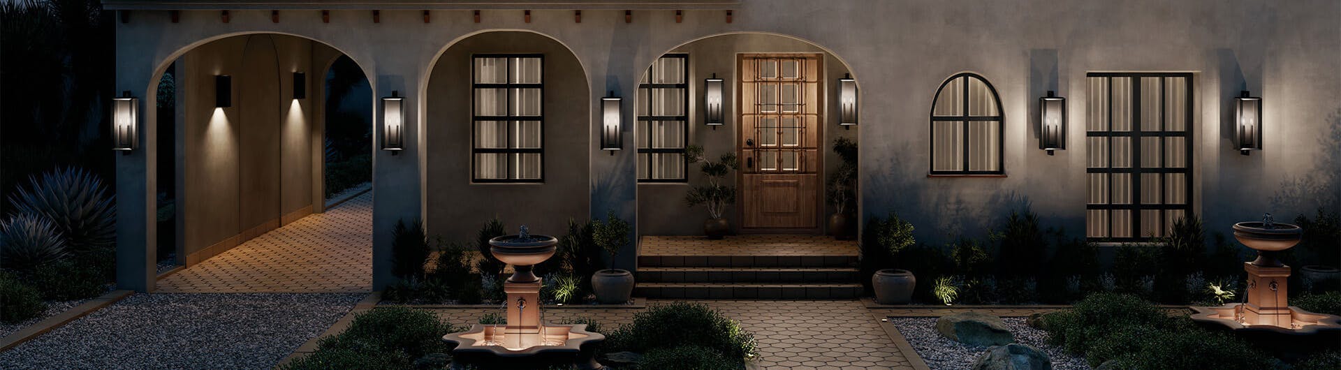 Exterior image of a grand front entrance lit up with Kroft exterior wall lights at night