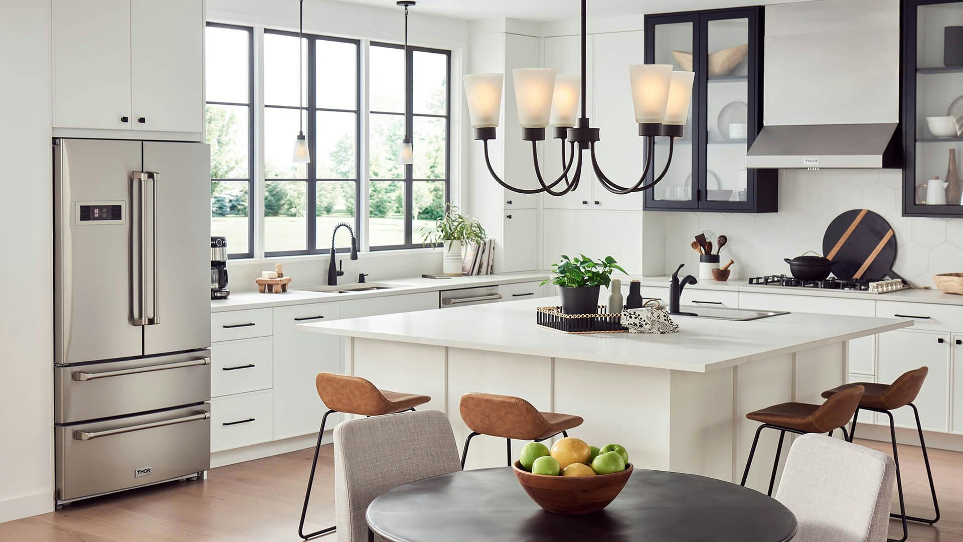 Modern kitchen during the day with large square kitchen island in the center featuring an Erma chandelier in black finish