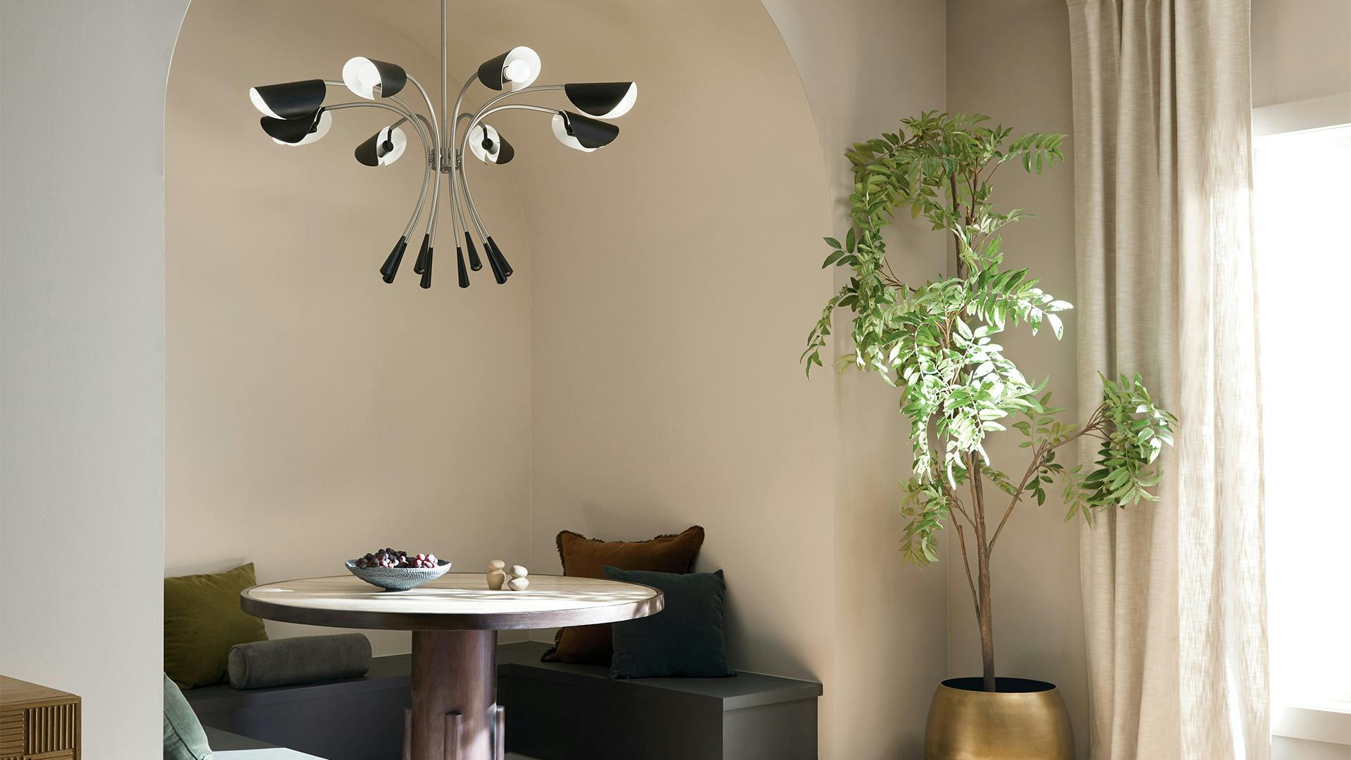 Arcus chandelier hanging over dining table tucked in a nook