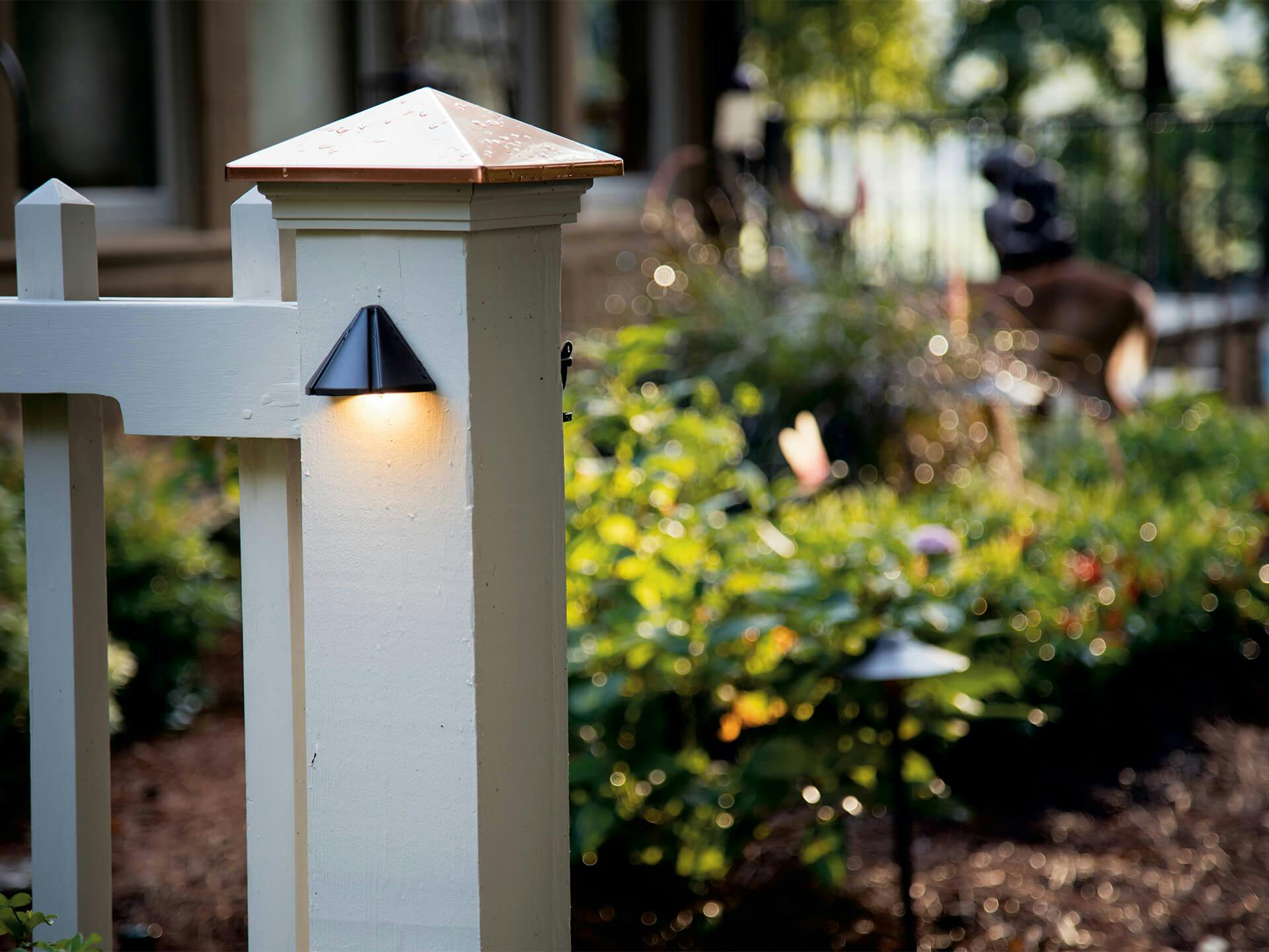 12 Volt Deck Light mounted on fence post outside a garden