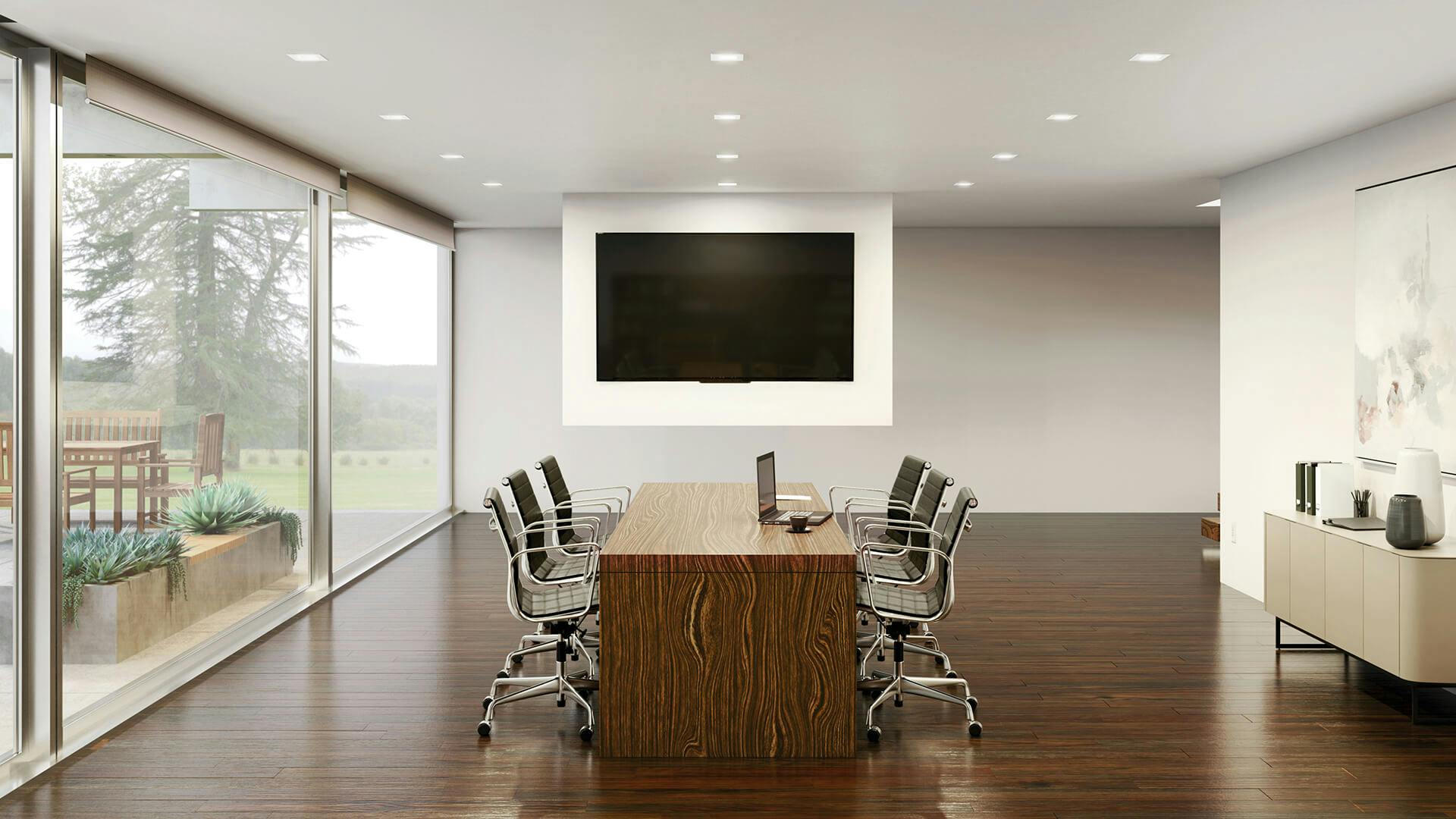 Large conference room with dark wood flooring and tables, featuring ceiling lights