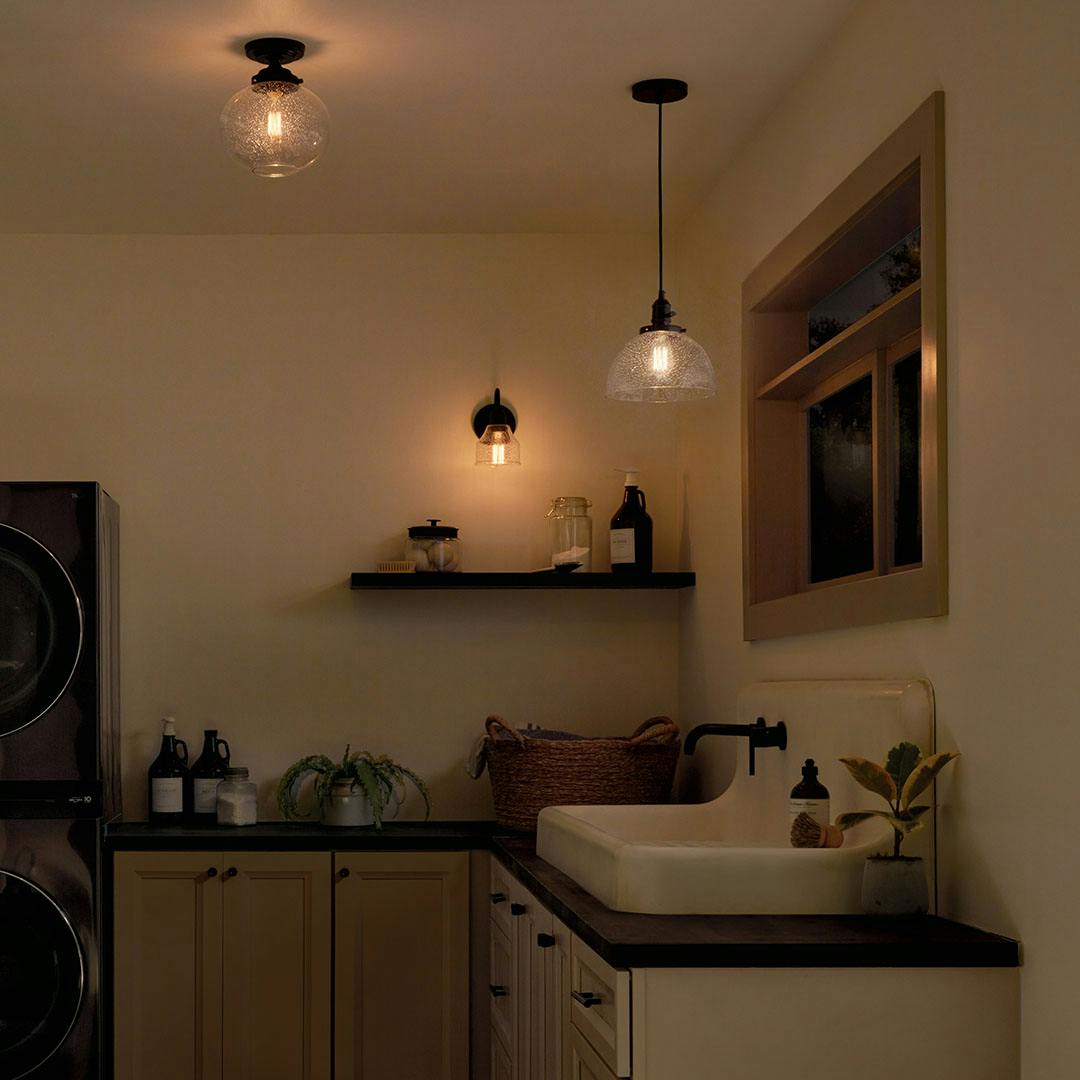 Laundry room at night with the Avery 9.5 Inch 1 Light Goblet Mini Pendant with Clear Seeded Glass in Black