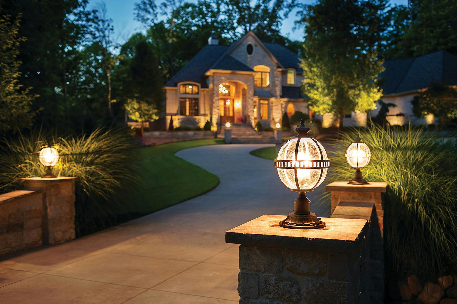 Night time driveway flanked by Halleron post lights and an illuminated home in the background