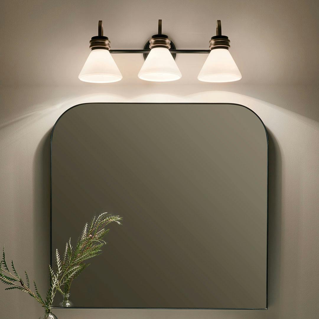 Night time bathroom with the Farum 26 Inch 3 Light Vanity with Opal Glass in Black with Champagne Bronze