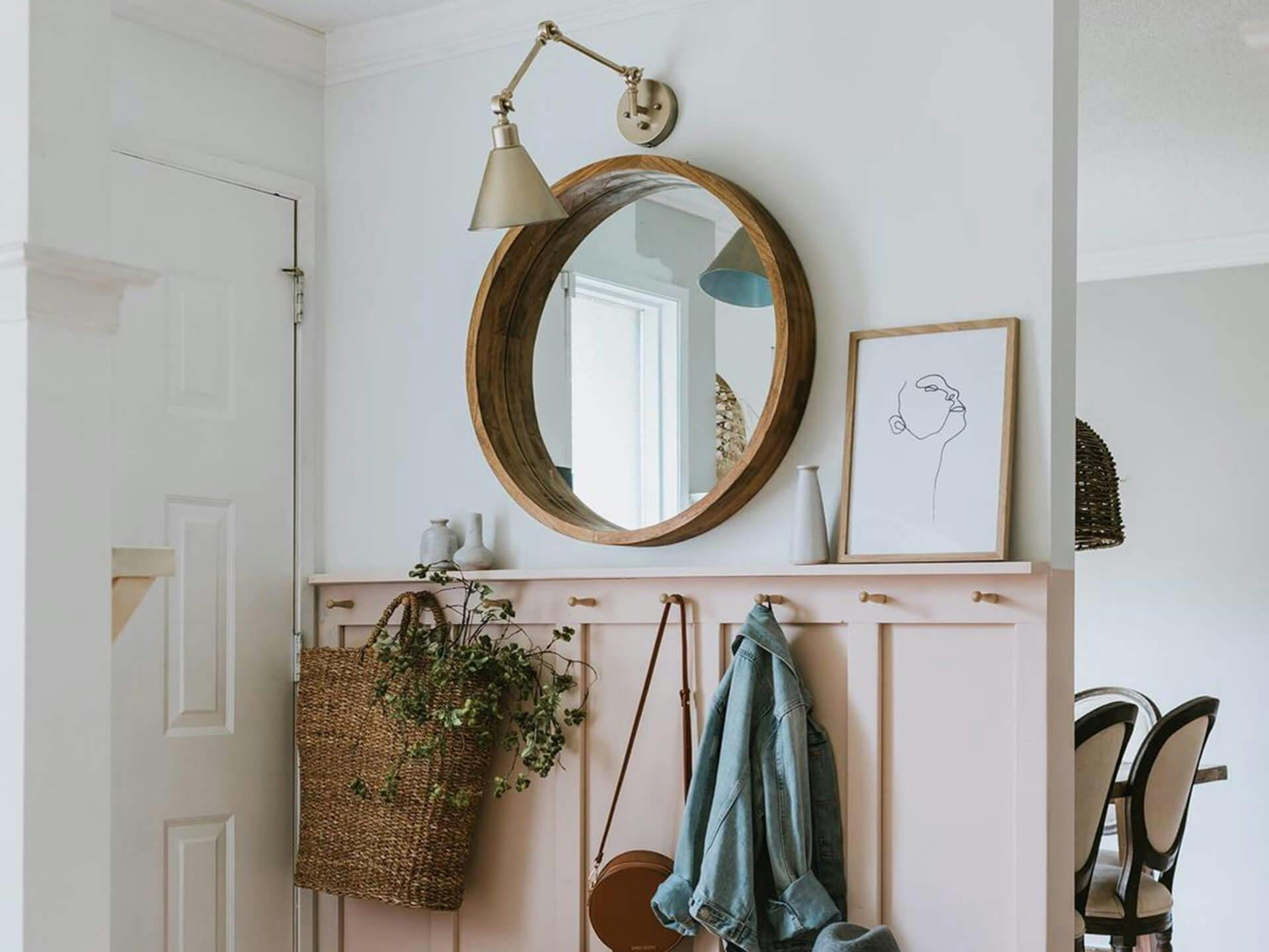 Entryway featuring a mirror beside the door with a natural brass Ellerbeck sconce mounted above it