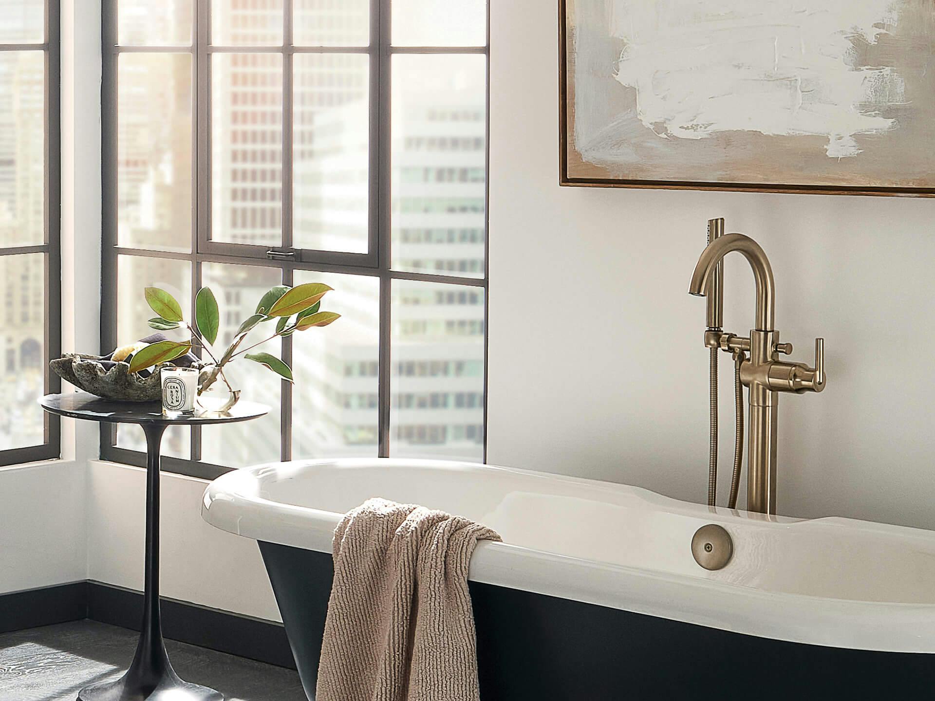 Bathroom at daytime featuring a widow-side bathtub with a Delta faucet in Champagne Bronze