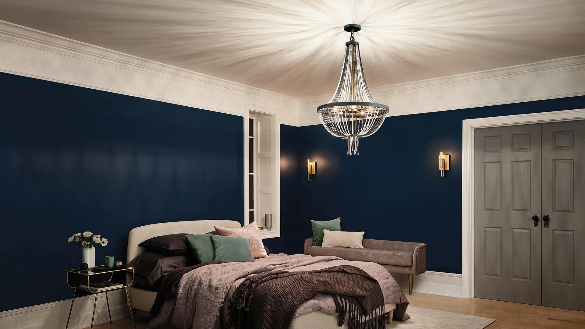 Bedroom with an Alexia chandelier casting sharp, angled shadows across the ceiling while two Alden sconces light the back wall