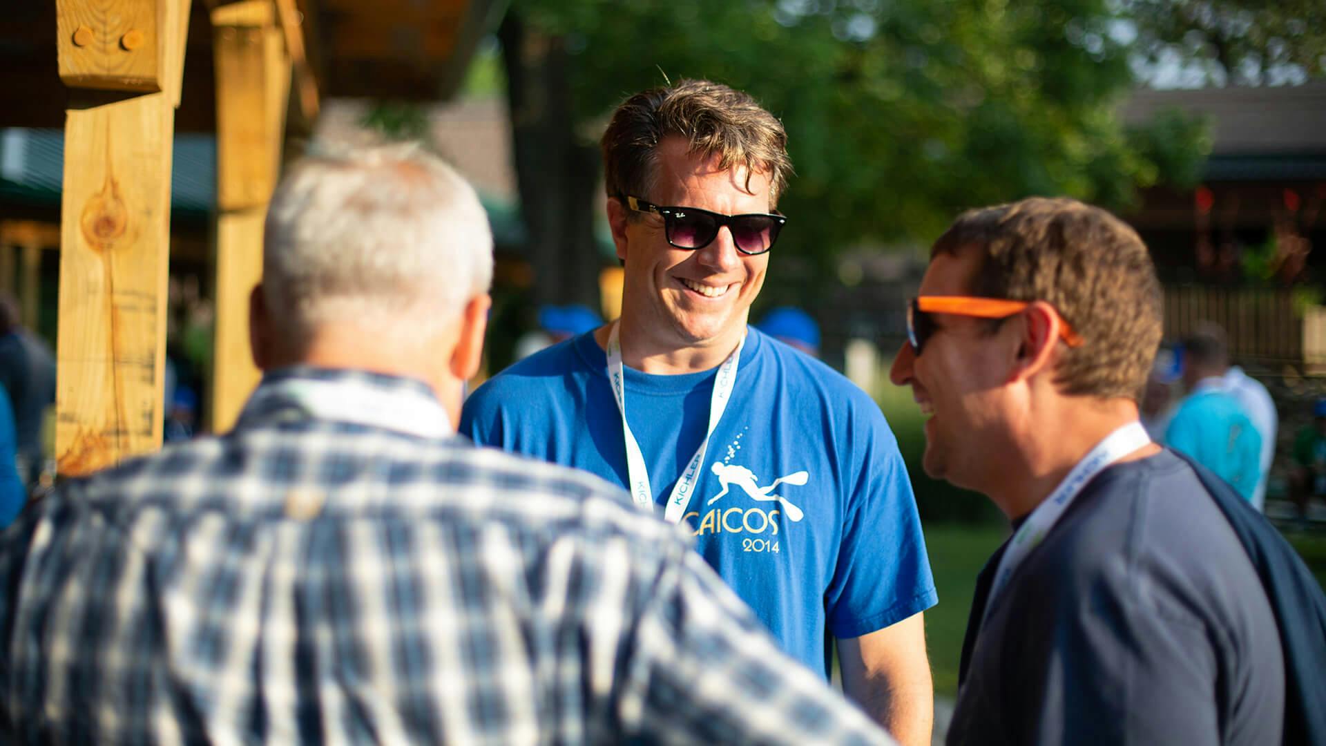 Three Light & Learn attendees smiling and conversing