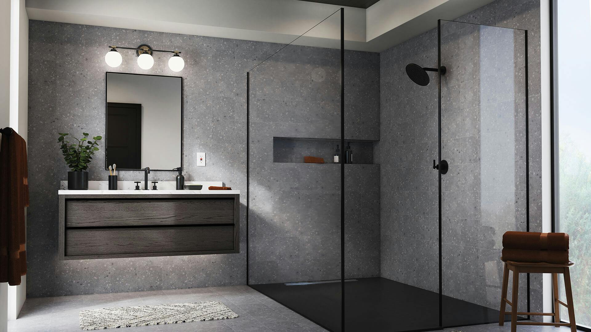 Gray tiled bathroom with glass show and Benno 3-light vanity light above floating wood vanity