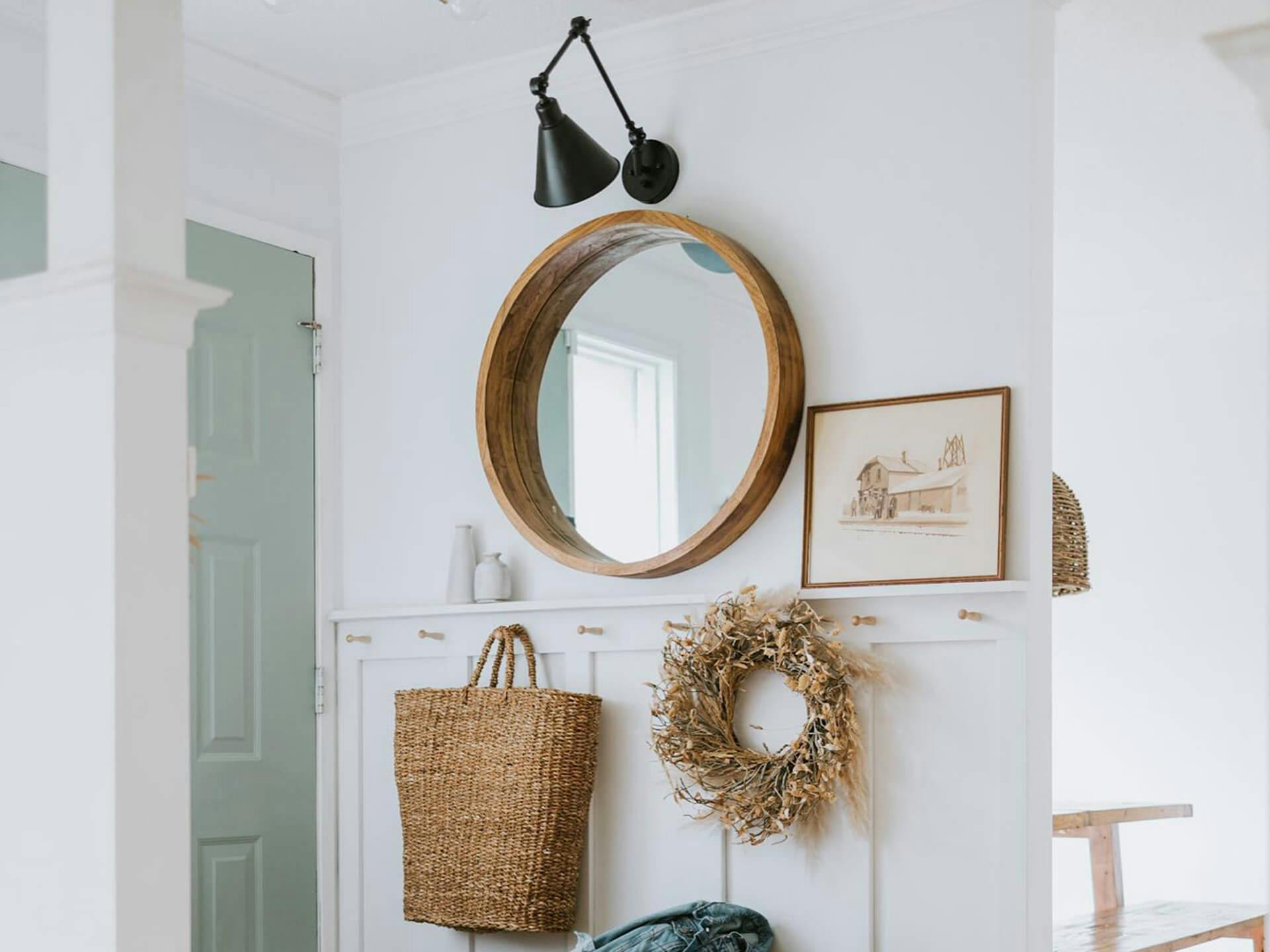 Entryway featuring a mirror beside the door with a black Ellerbeck sconce mounted above it