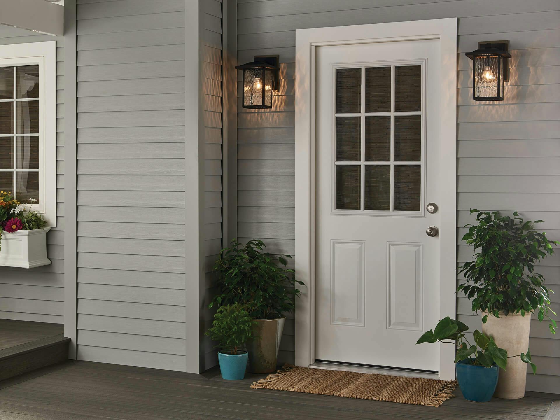 Front porch with two black capanna sconces on either side of a white front door.