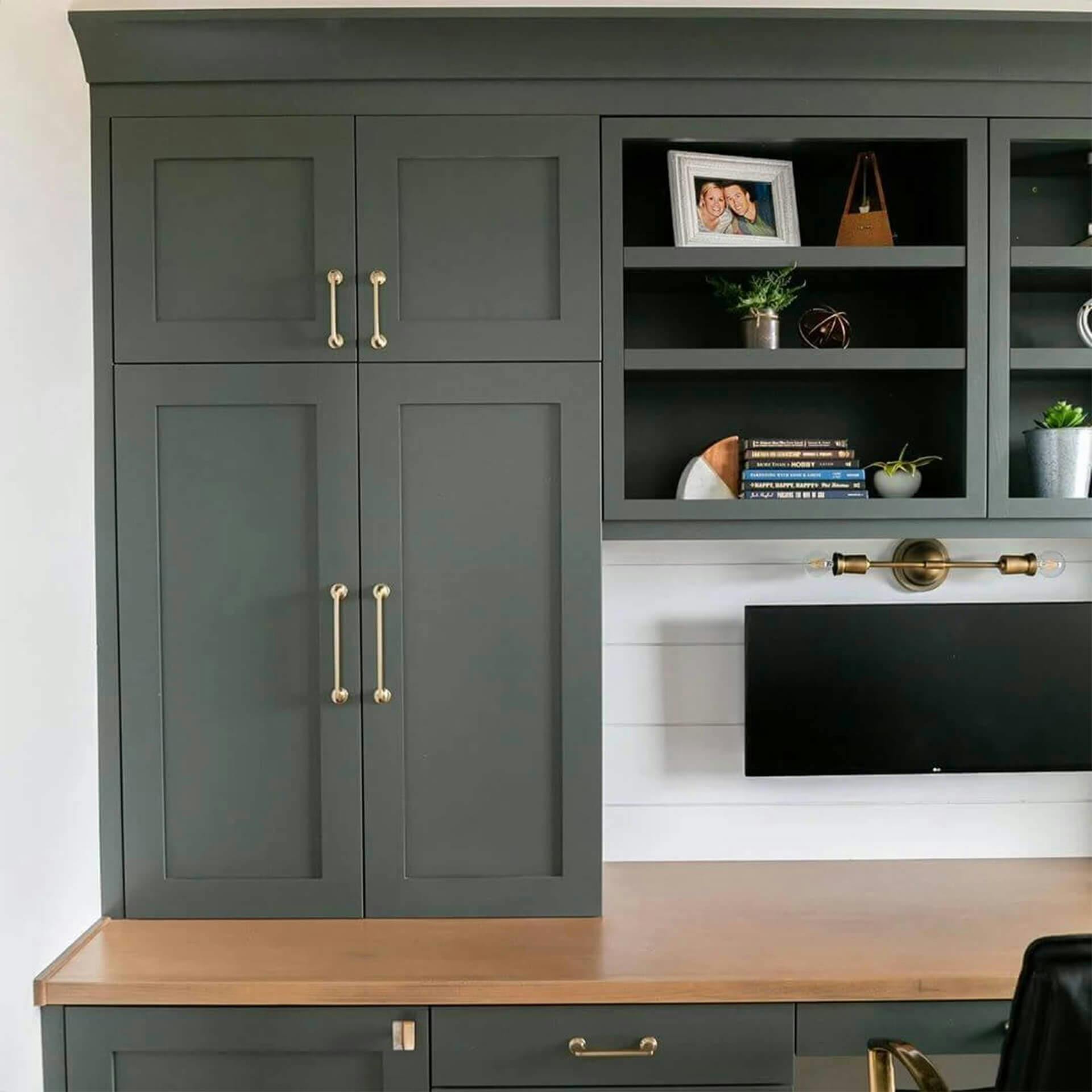 Built in green cabinets surround a desk space