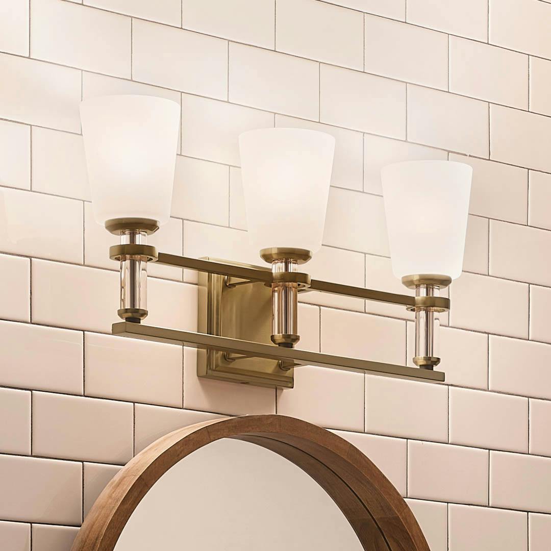 Night time bathroom with Rosalind 11.5" 3 Light Vanity Light Brushed Natural Brass