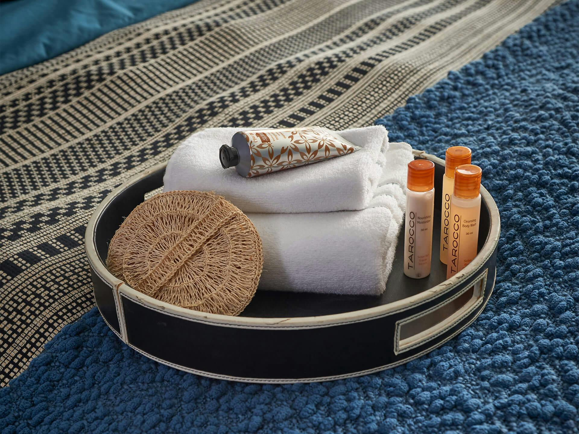 Lifestyle image of a basket filled with towels, lotion, and soap 
