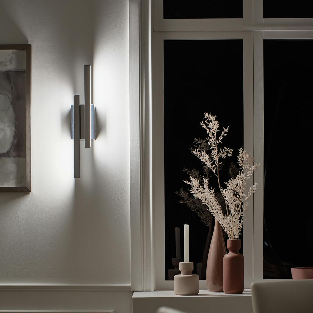 Night time dining room with the Idril™ LED Wall Sconce in Chrome