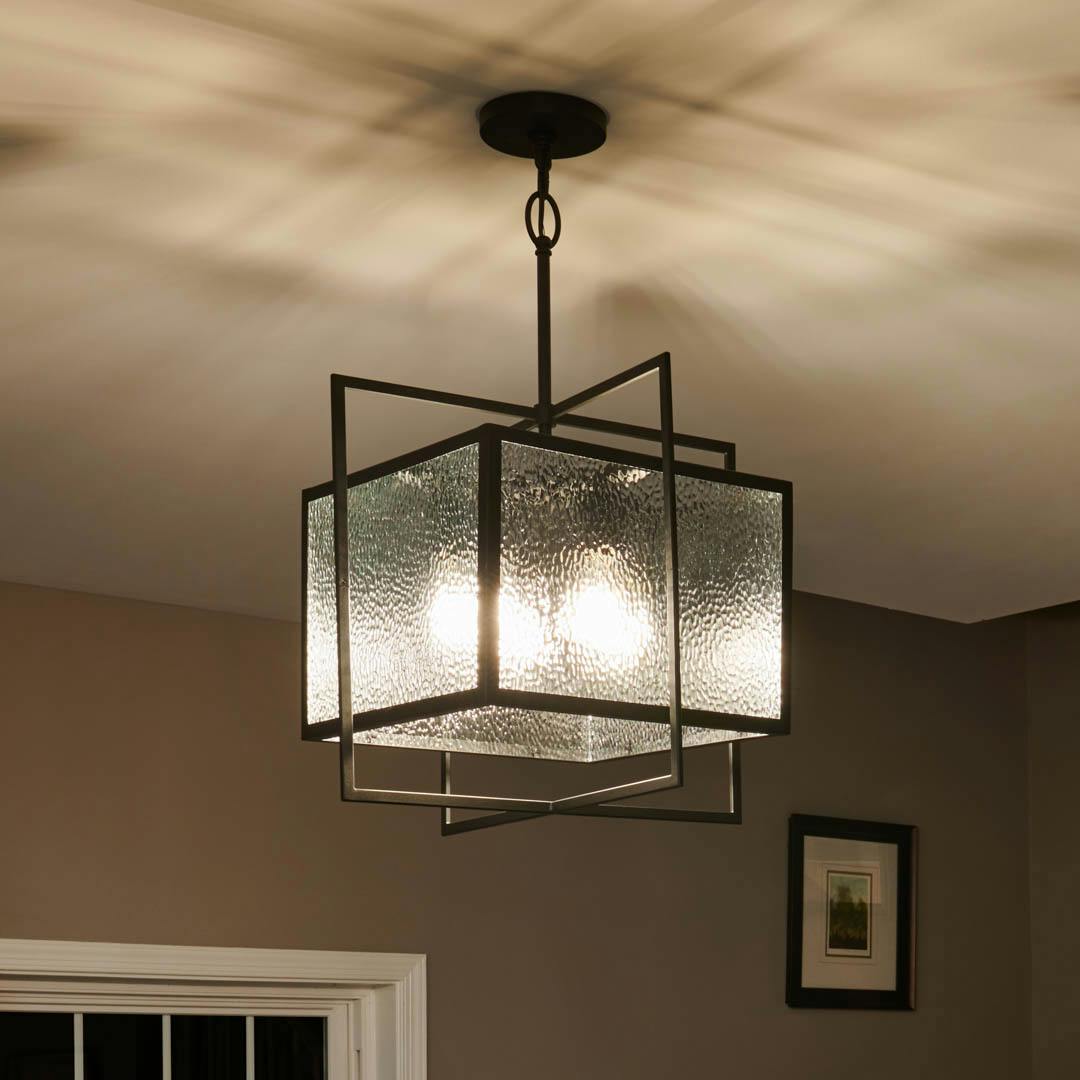 Night time foyer with Edinborough 4 Light Pendant in Textured Black with Clear Hammered Glass