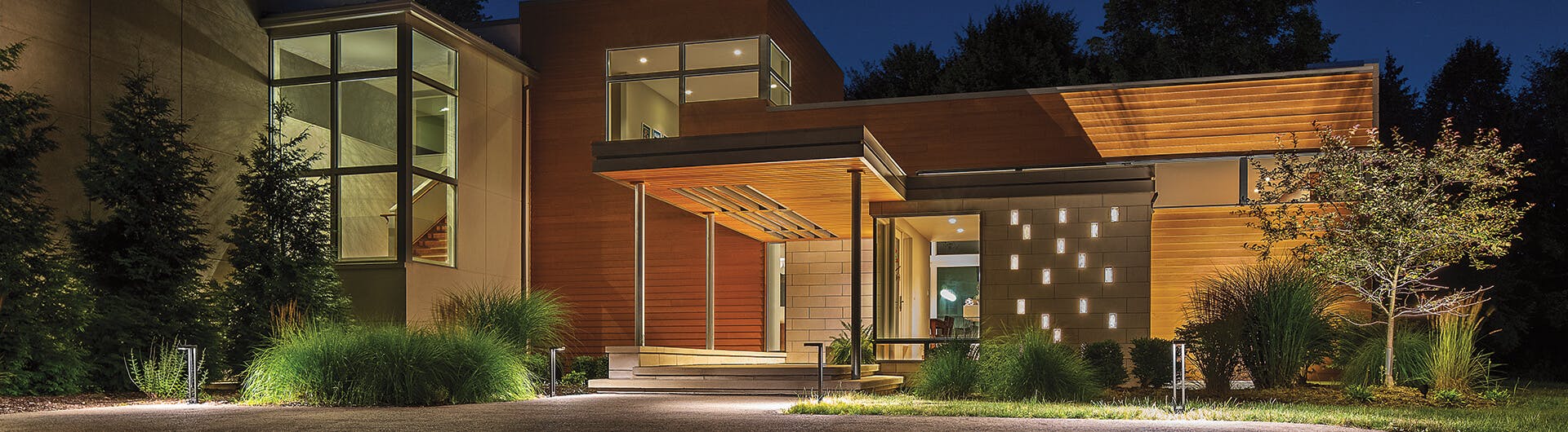Well-lit house exterior with several two arm path light in architectural bronze lining the pathway