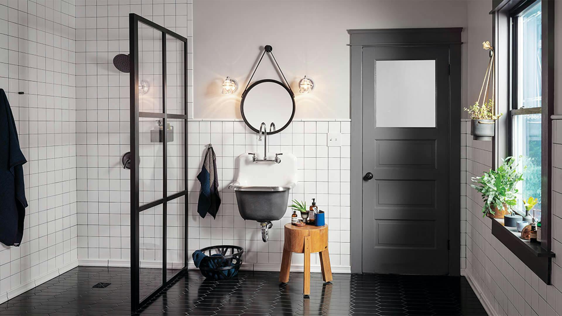 A modern bathroom lit with Talland vanity lights above an industrial style bathroom sink in the daytime 