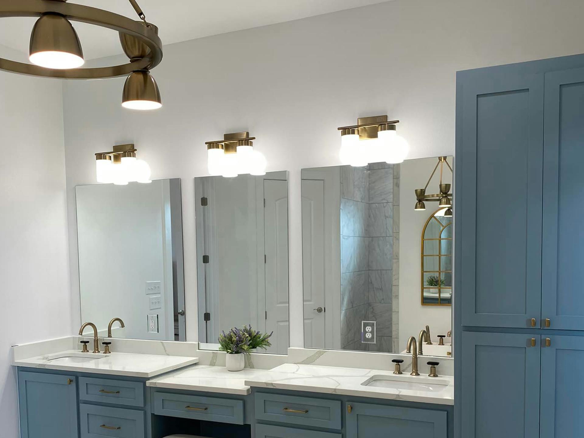 Bathroom vanity with 2 sinks and 3 mirrors. Kichler vanity lights hanging overhead