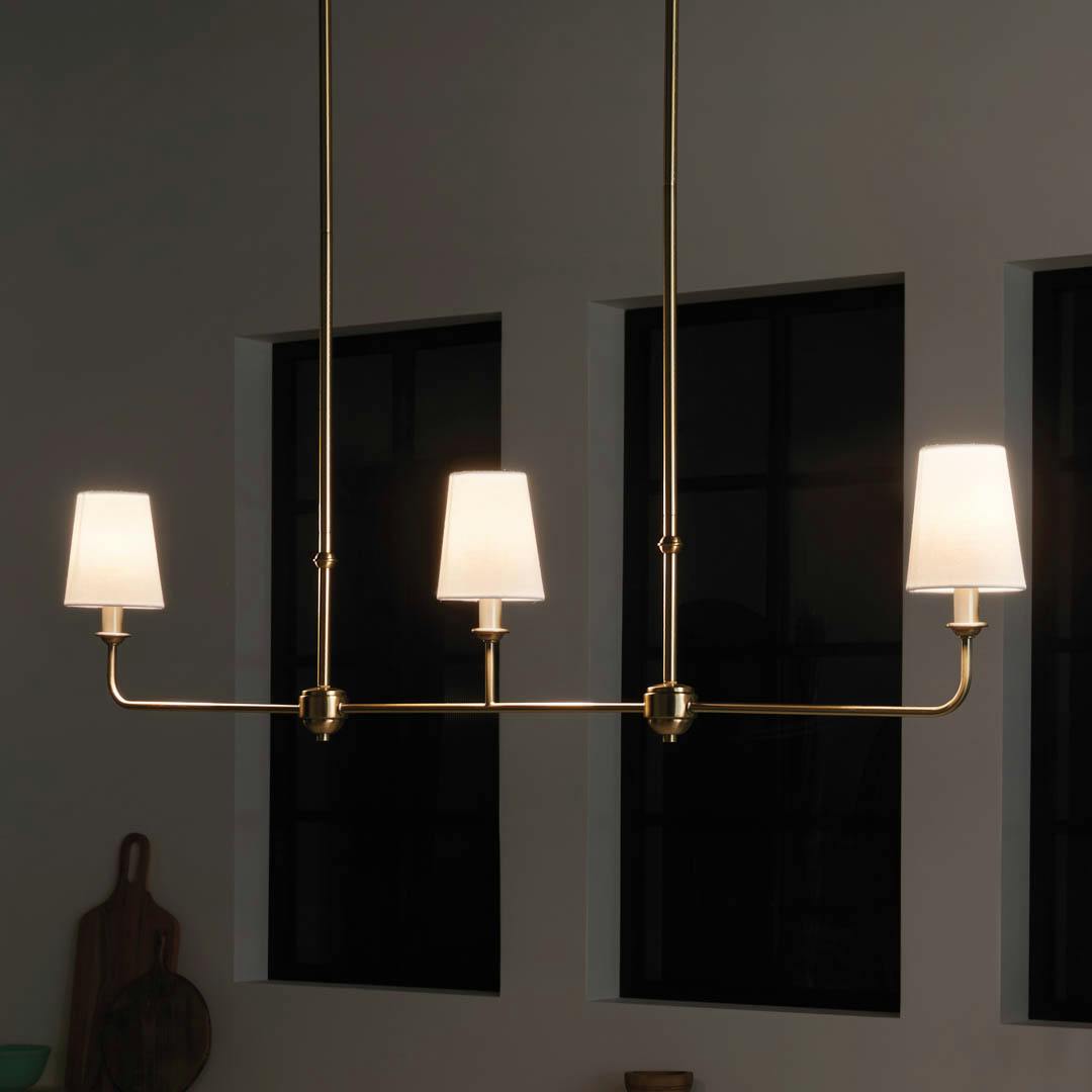 Night time kitchen with Pallas 48.25" 3 Light Linear Chandelier Brushed Natural Brass