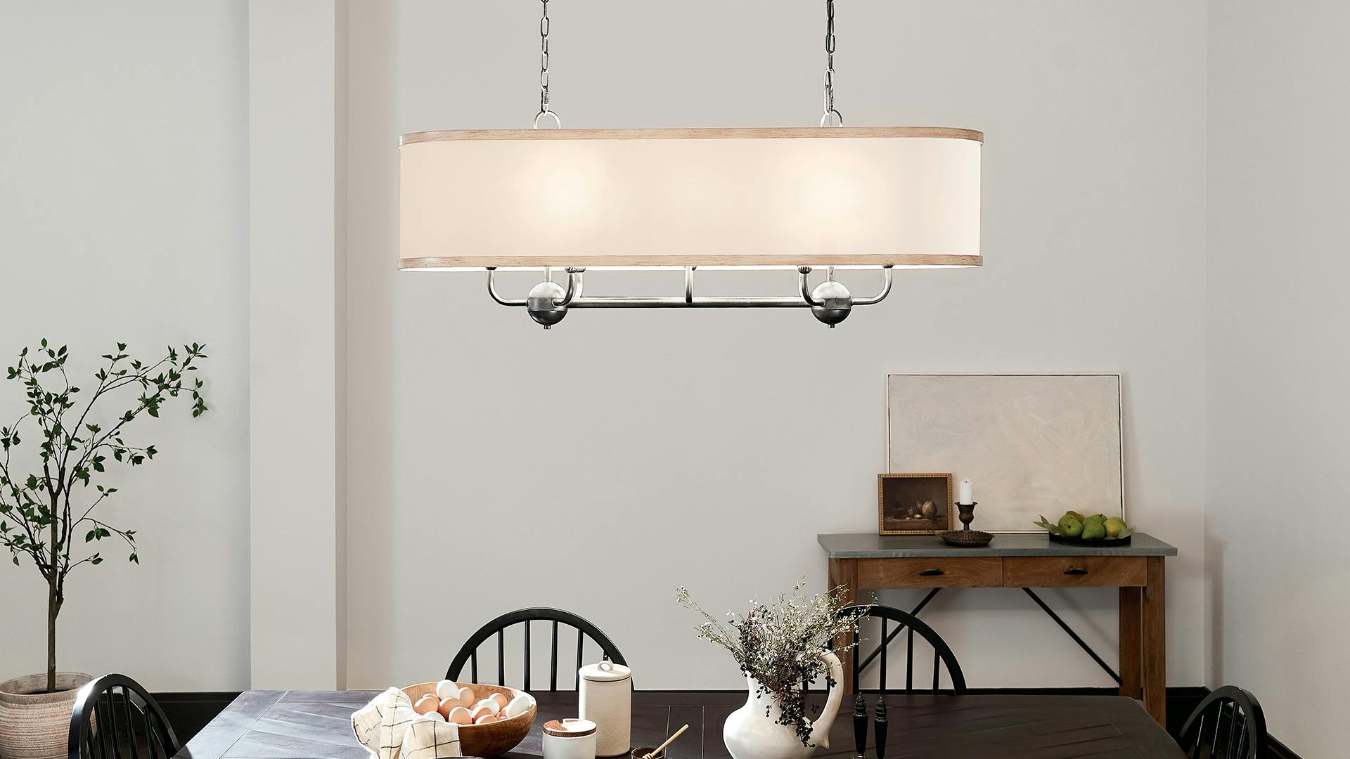 Heddle 8 light Linear Chandelier hanging over dining room table