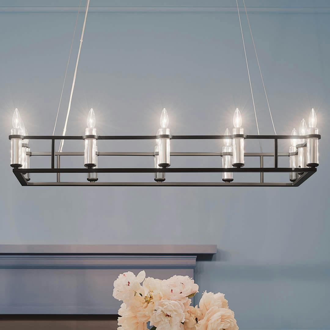 Night time dining room with Rosalind 45.25" 12 Light Linear Chandelier Black