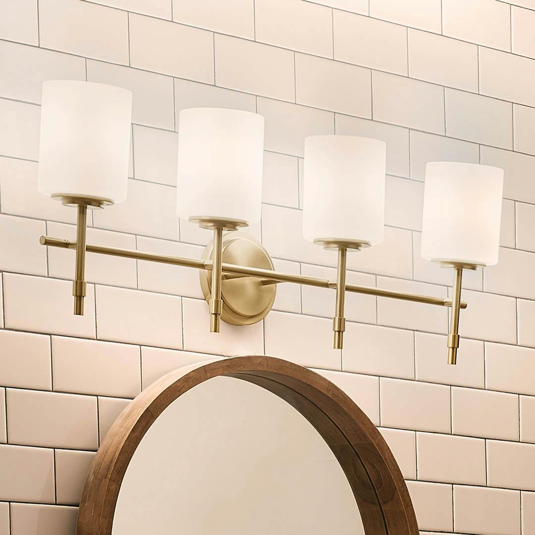 Night time bathroom with Ali 11.25" 4 Light Vanity Brushed Natural Brass