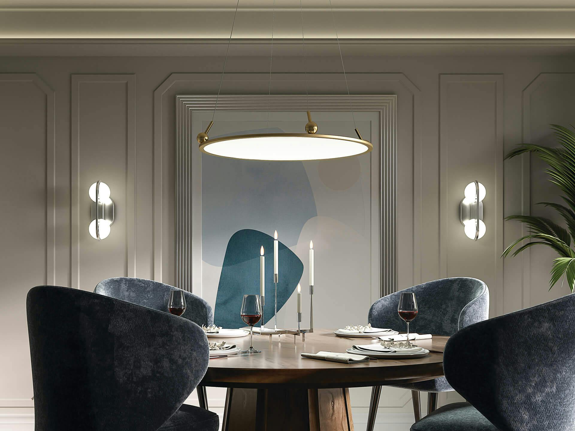 Dining room with round table and velvet arm chairs featuring a Jovian chandelier in gold finish