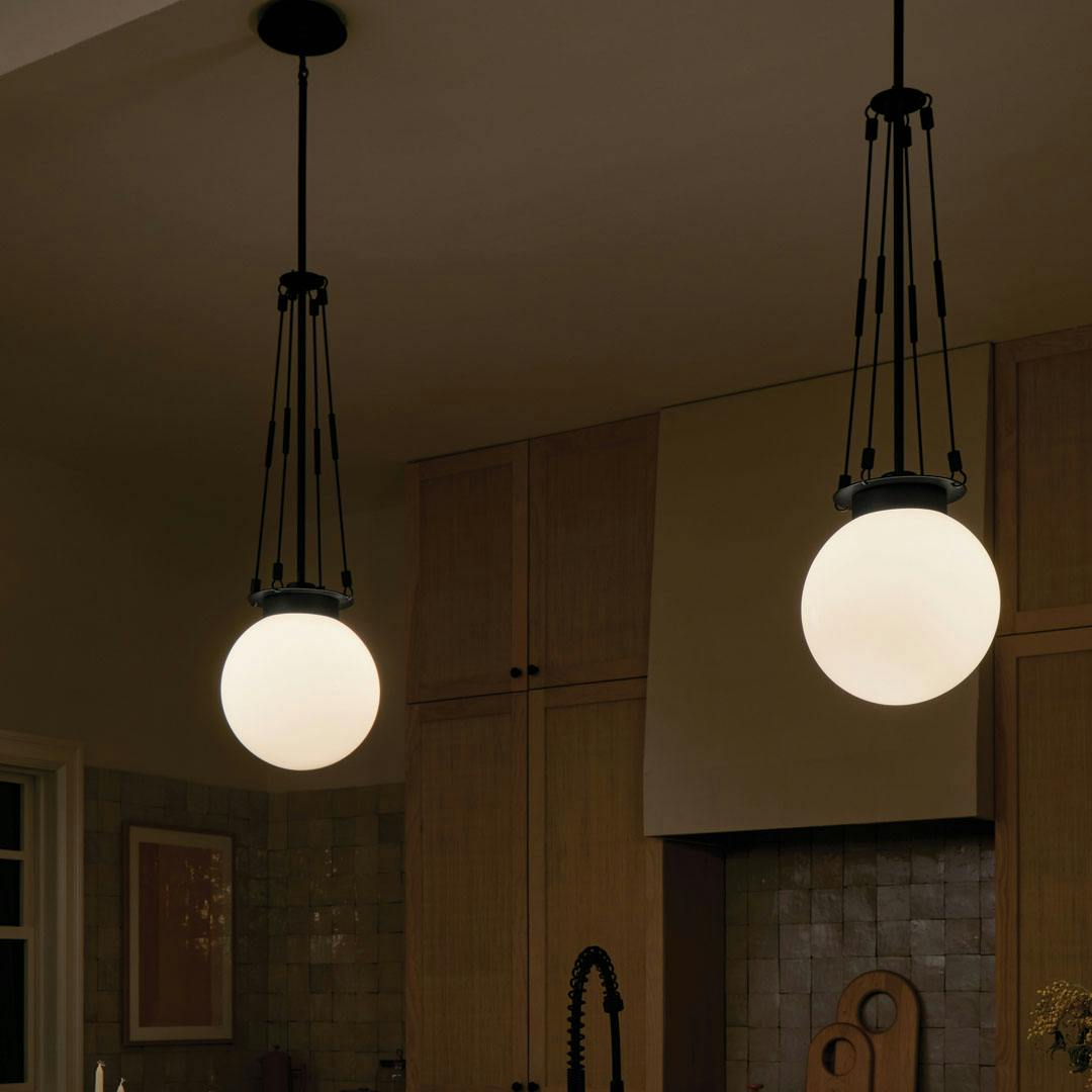 Night time kitchen with the Albers 10.5 Inch 1 Light Pendant with Opal Glass in Black