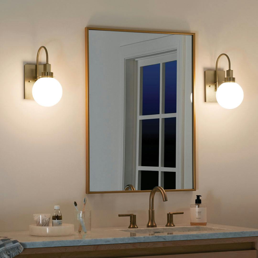 Bathroom at night with the Hex 11.5 Inch 1 Light Wall Sconce with Opal Glass in Champagne Bronze