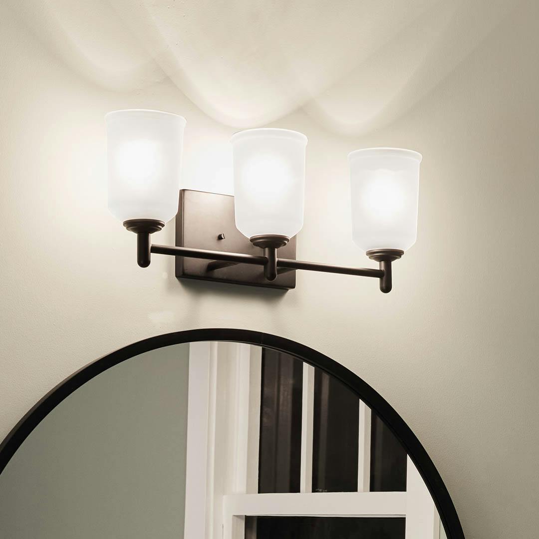 Night time bathroom with Shailene 21.25 inch 3 Light Vanity Light with Satin Etched Glass in Black