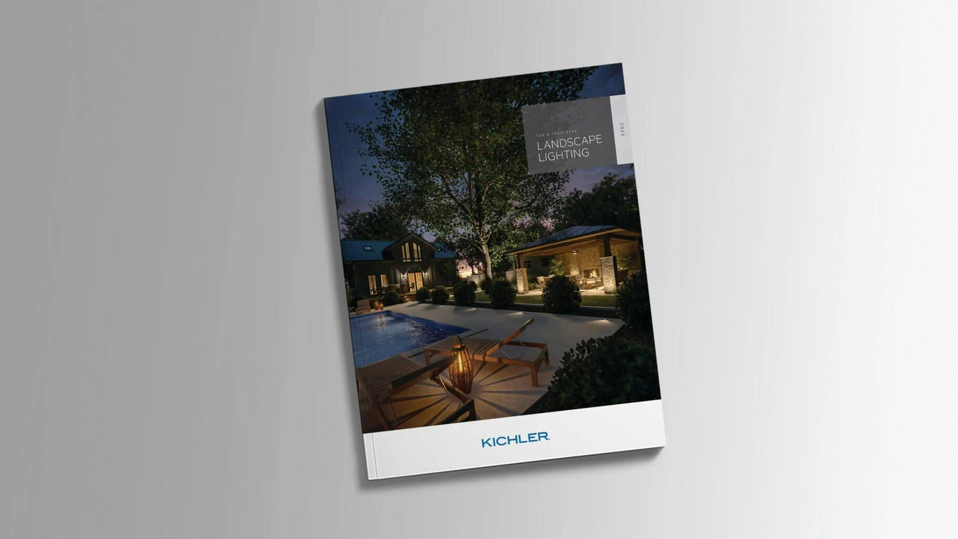 Catalog cover featuring an outdoor pool at night with variety of lighting shining out from poolhouse spaces and titled landscape lighting