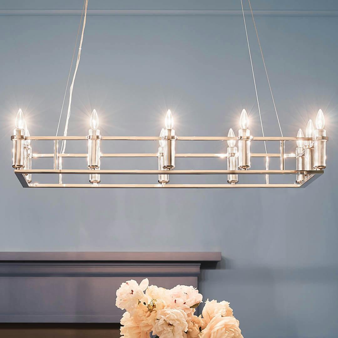Night time dining room with Rosalind 45.25" 12 Light Linear Chandelier Polished Nickel