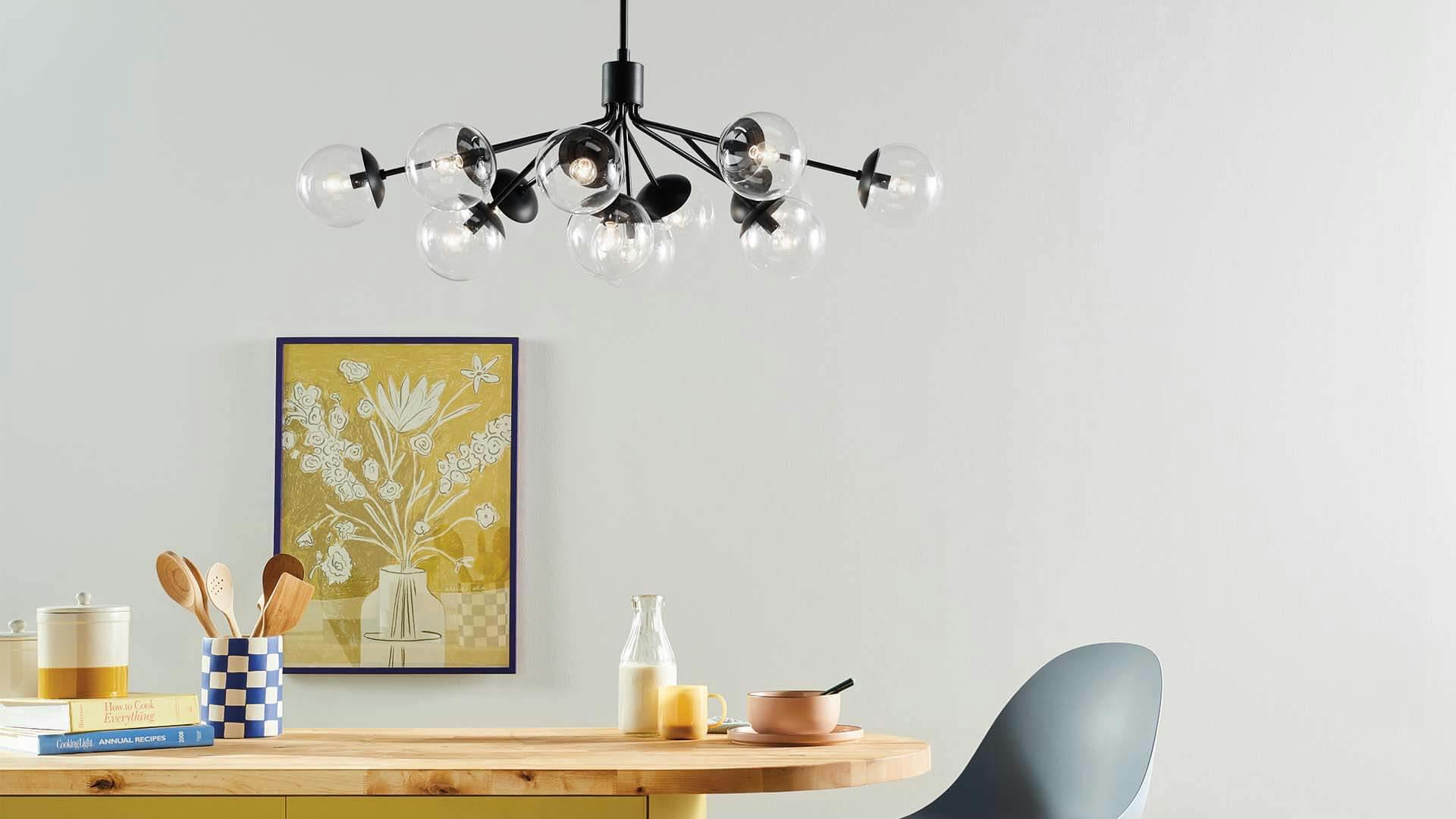 Kitchen table with a floral painting and Silvarious 12-light chandelier with clear glass and black finish