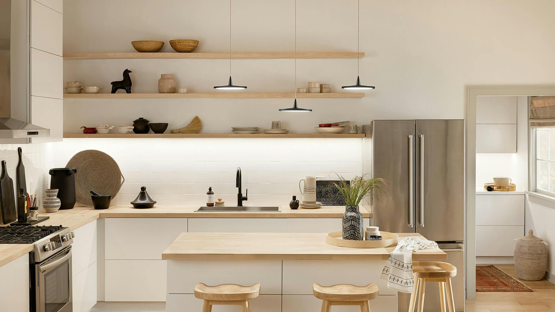 Scandinavian style Kitchen with three Jeno pendants over a wooden kitchen island with tape lights lighting up a shelf on the back wall 