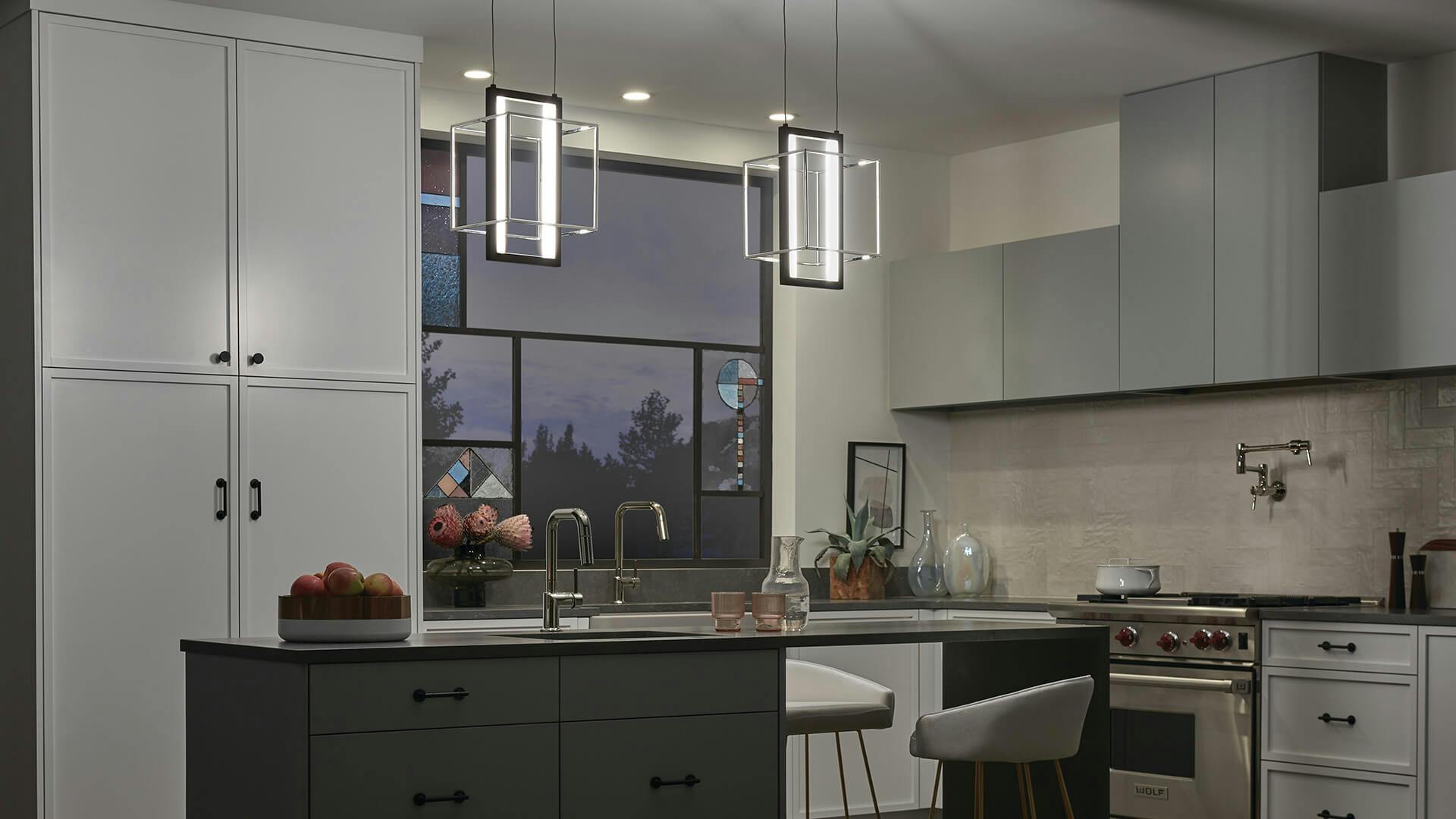 Modern kitchen at night with two Viho pendant lights hanging above a kitchen island