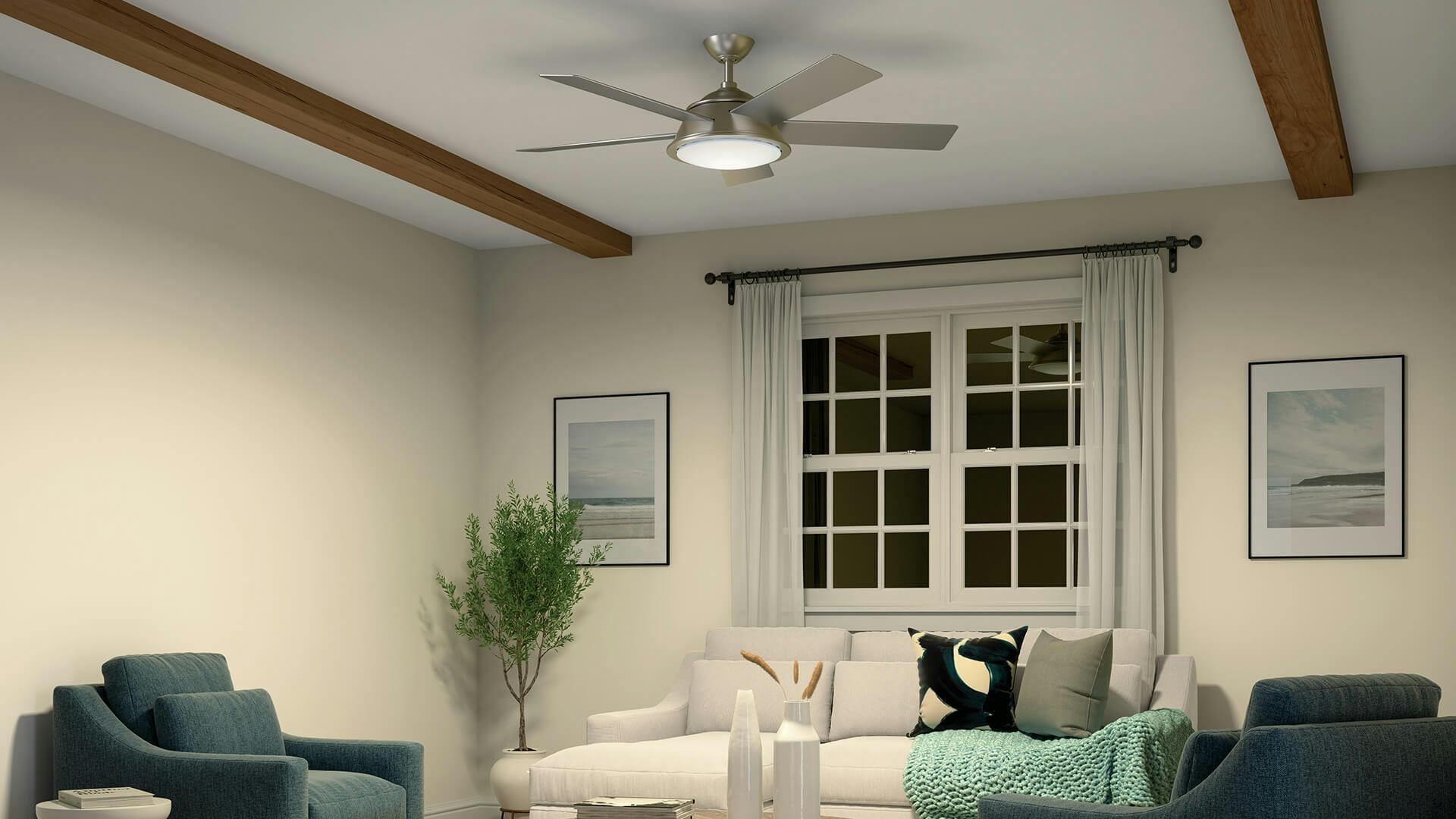 Living room at night featuring a Verdi ceiling fan lit against a white ceiling with wooden beams running along each side of it