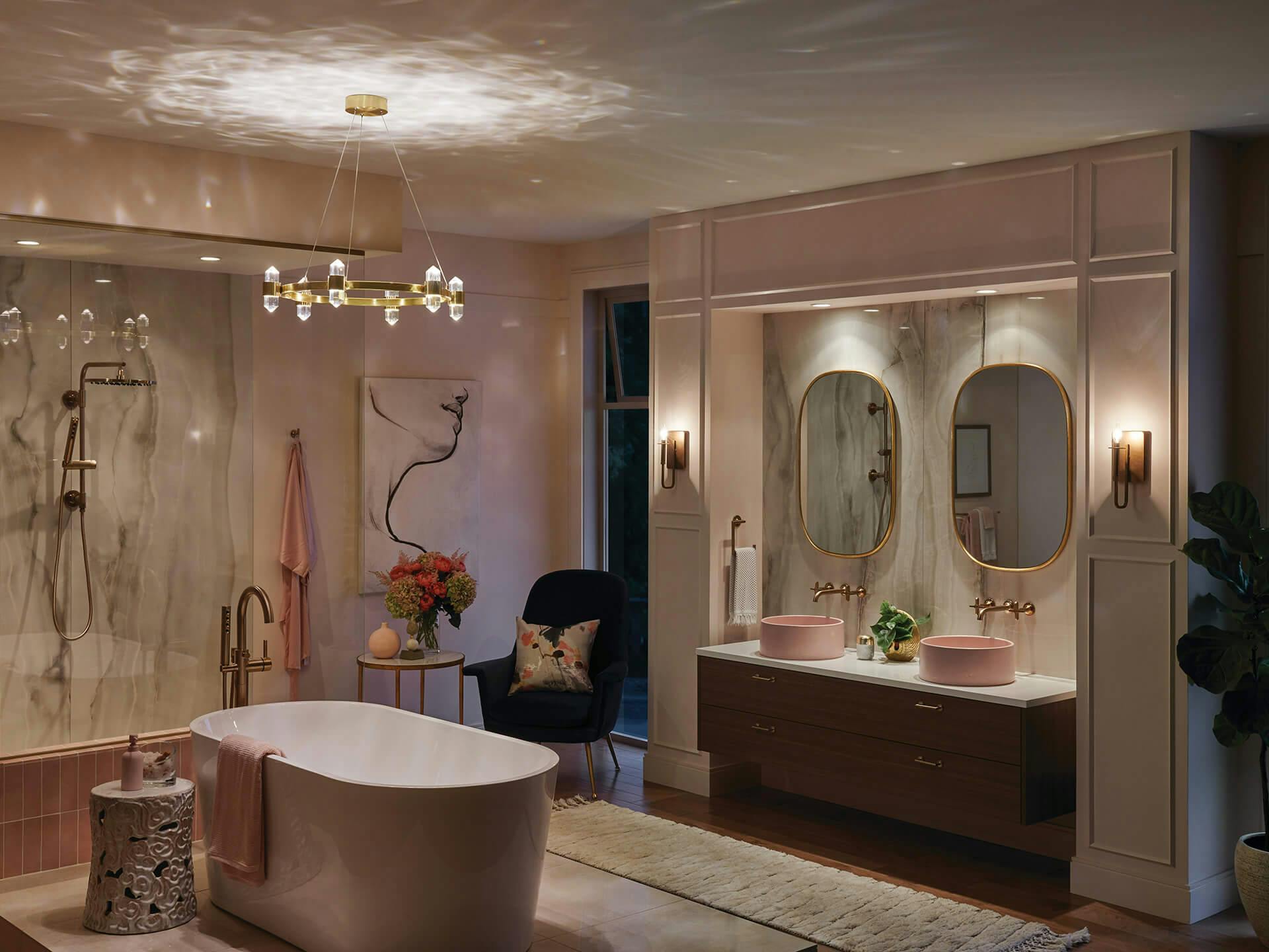 Evening luxurious pink bathroom with a tub in the middle of the room featuring an Arabella chandelier at night