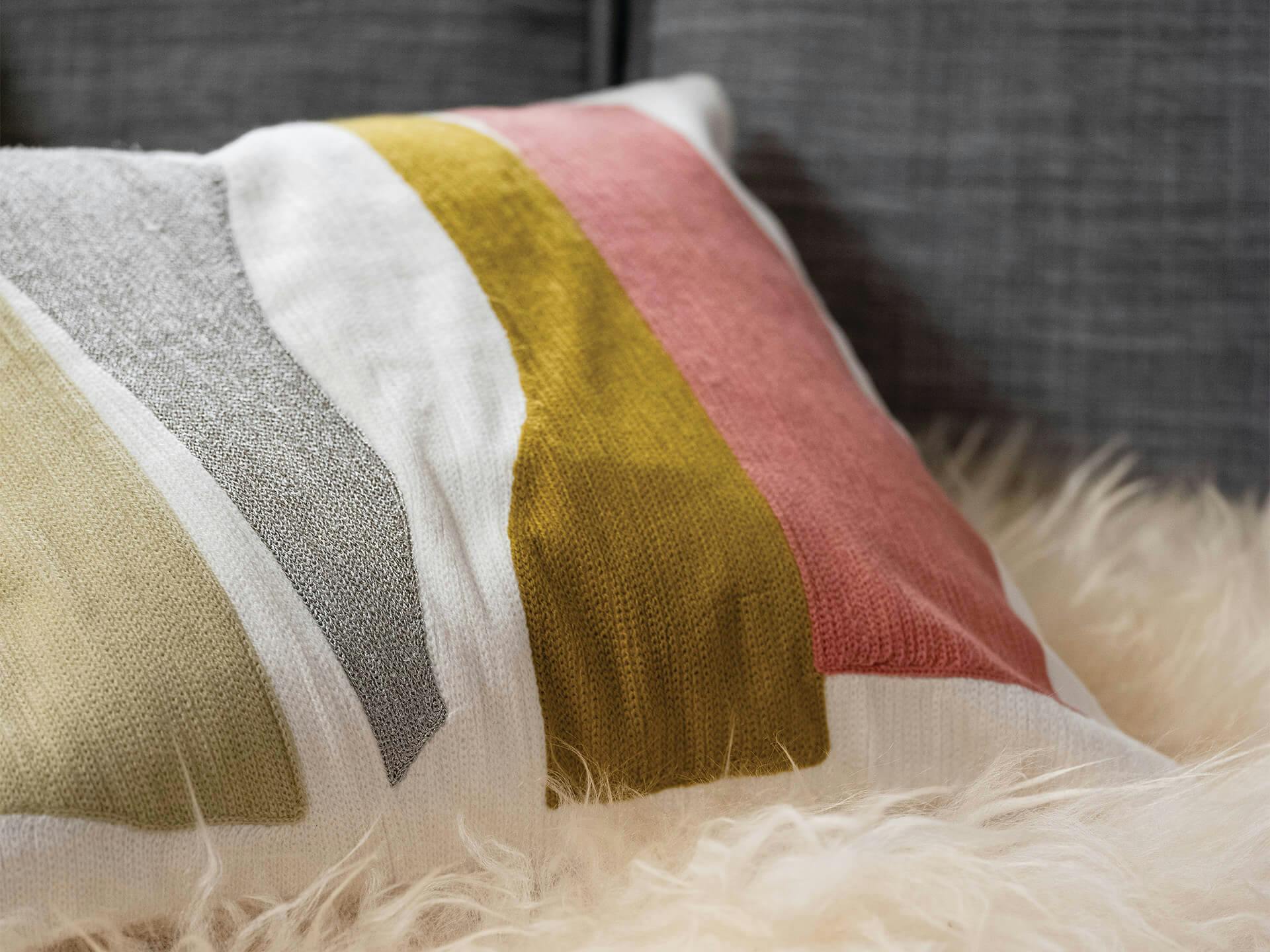 Close up of a colorful pillow on a couch