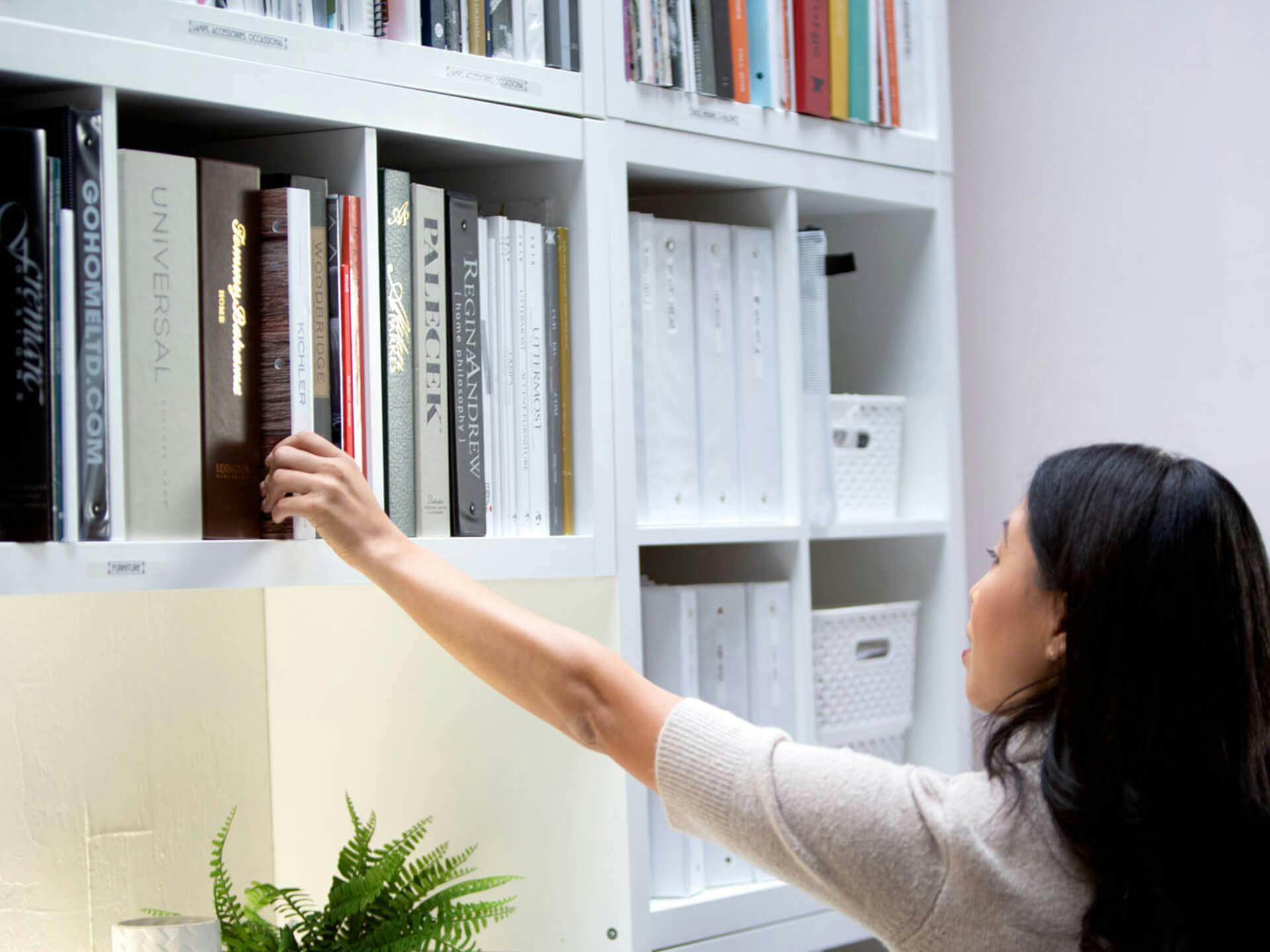 Kichler consultant pulling a book off a shelf