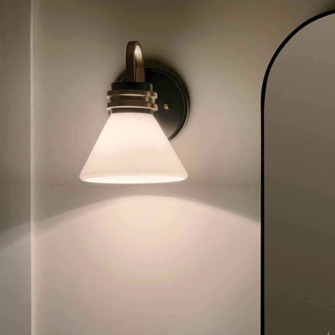 Night time bathroom with the Farum 9.5 Inch 1 Light Wall Sconce with Opal Glass in Black with Champagne Bronze