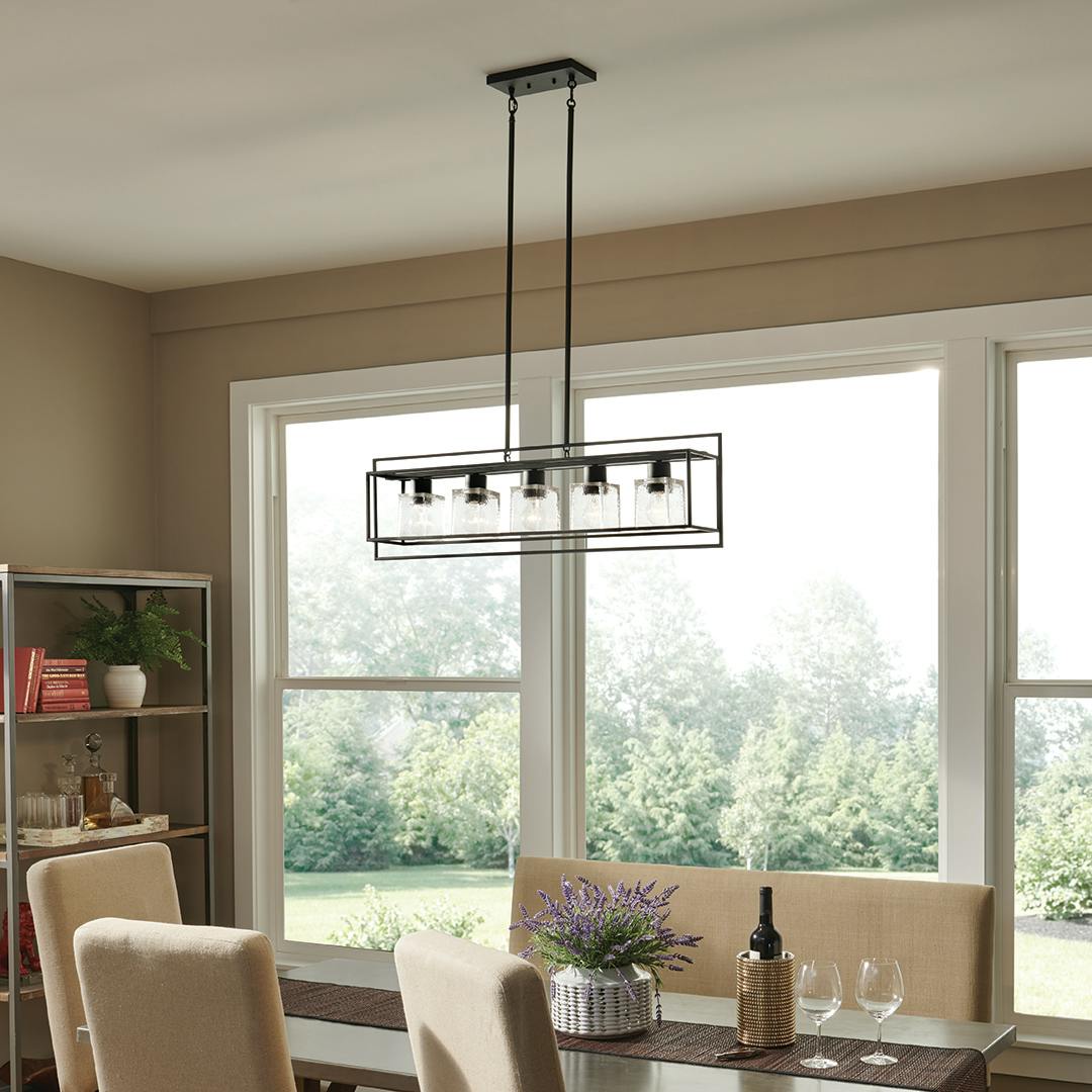 Day time dining room with Edinborough 5 Light Linear Chandelier in Textured Black with Clear Hammered Glass