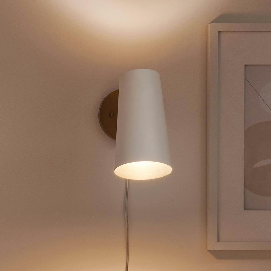 Night time office with Salema 9 Inch 1 Light  Plug-In Wall Sconce in Natural Brass and White