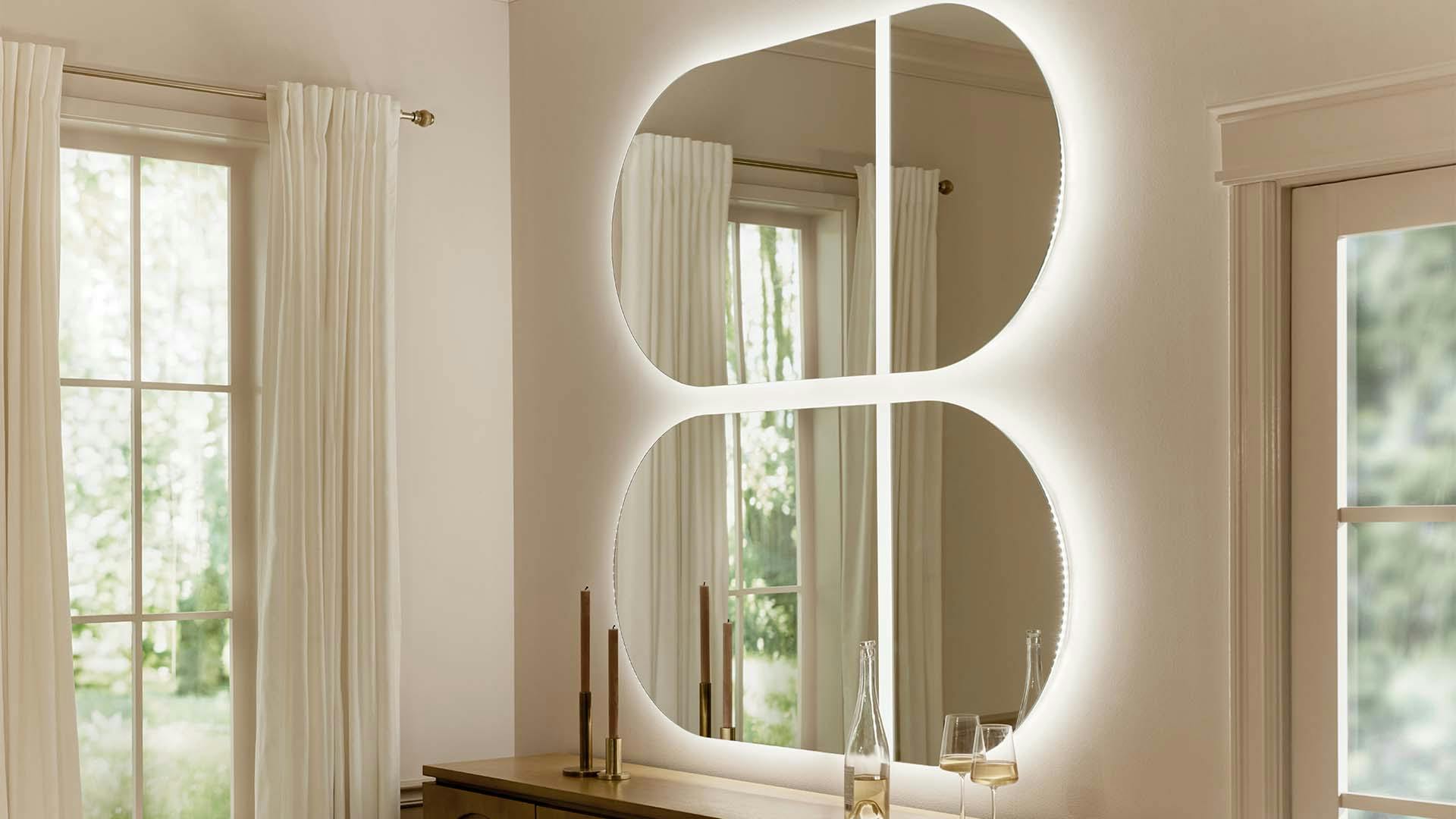 Two oval mirrors with backlighting in a dining room