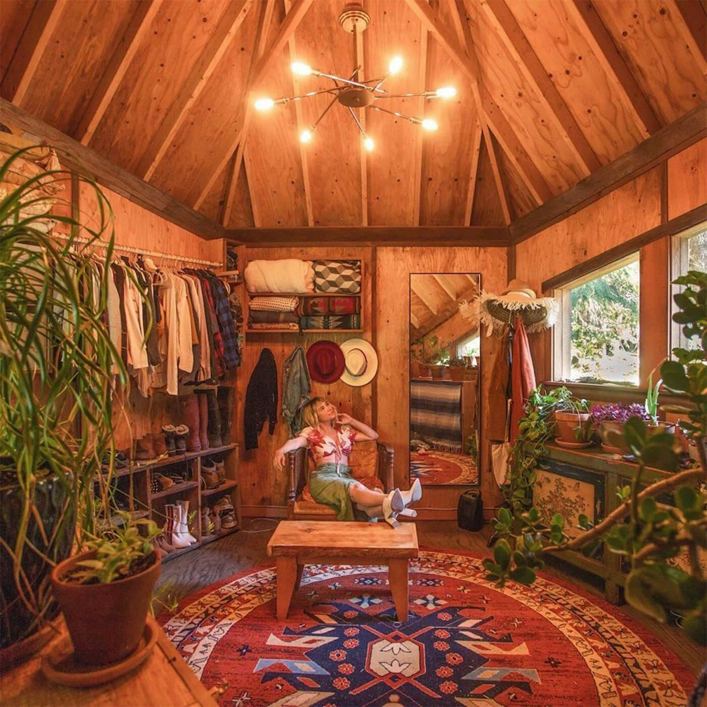 Jacob Witzling Instagram image of a rustic cabin walk in closet with warm glow from hanging chandelier