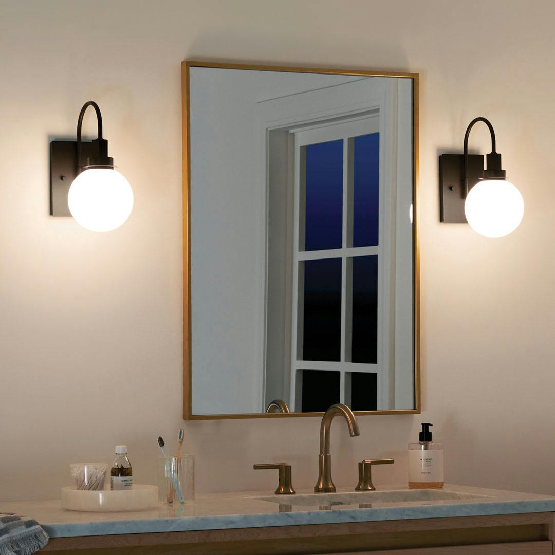 Bathroom at night with the Hex 11.5 Inch 1 Light Wall Sconce with Opal Glass in Black
