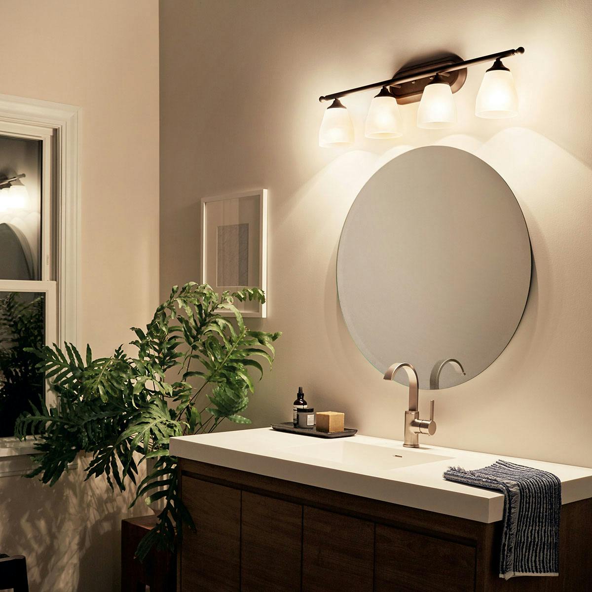 Night time Bathroom featuring Ansonia vanity light 5449OZ