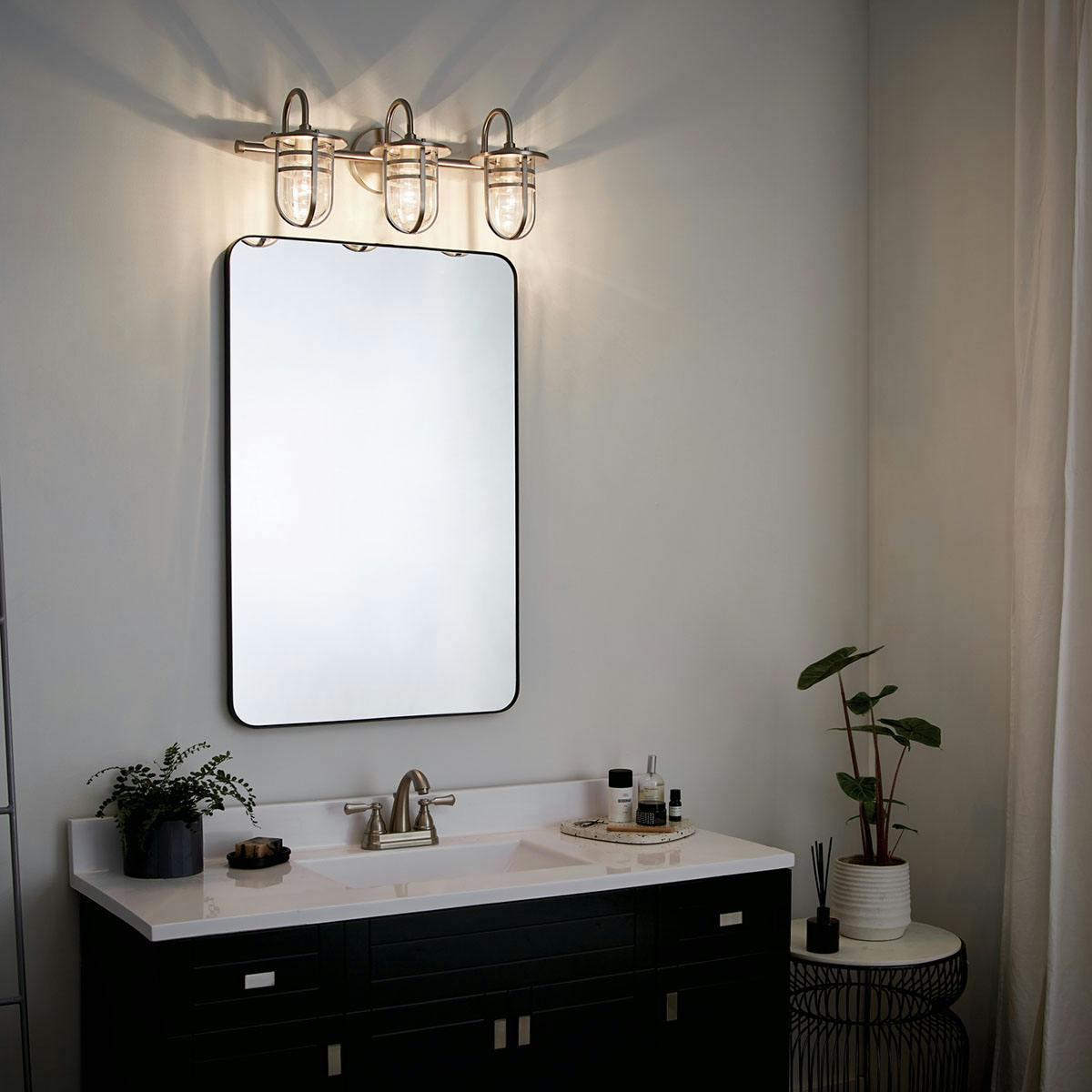 Night time Bathroom featuring Caparros vanity light 45133NI
