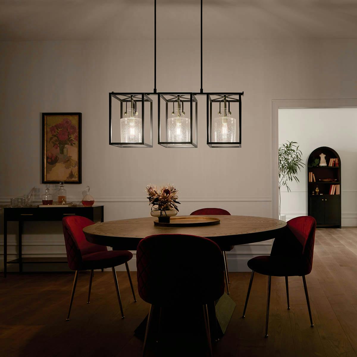night time dining room with Kitner 3 light chandelier Natural Brass